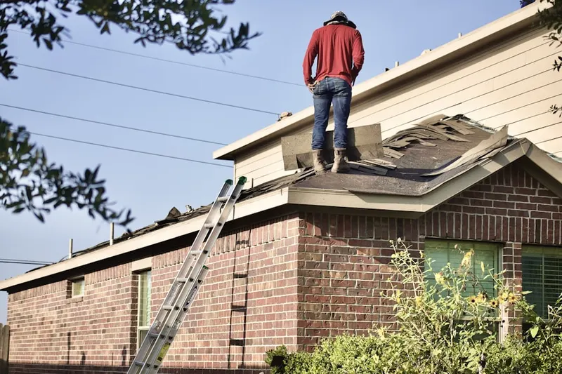 Professional roofer working on a residential roof in Helsing Junction